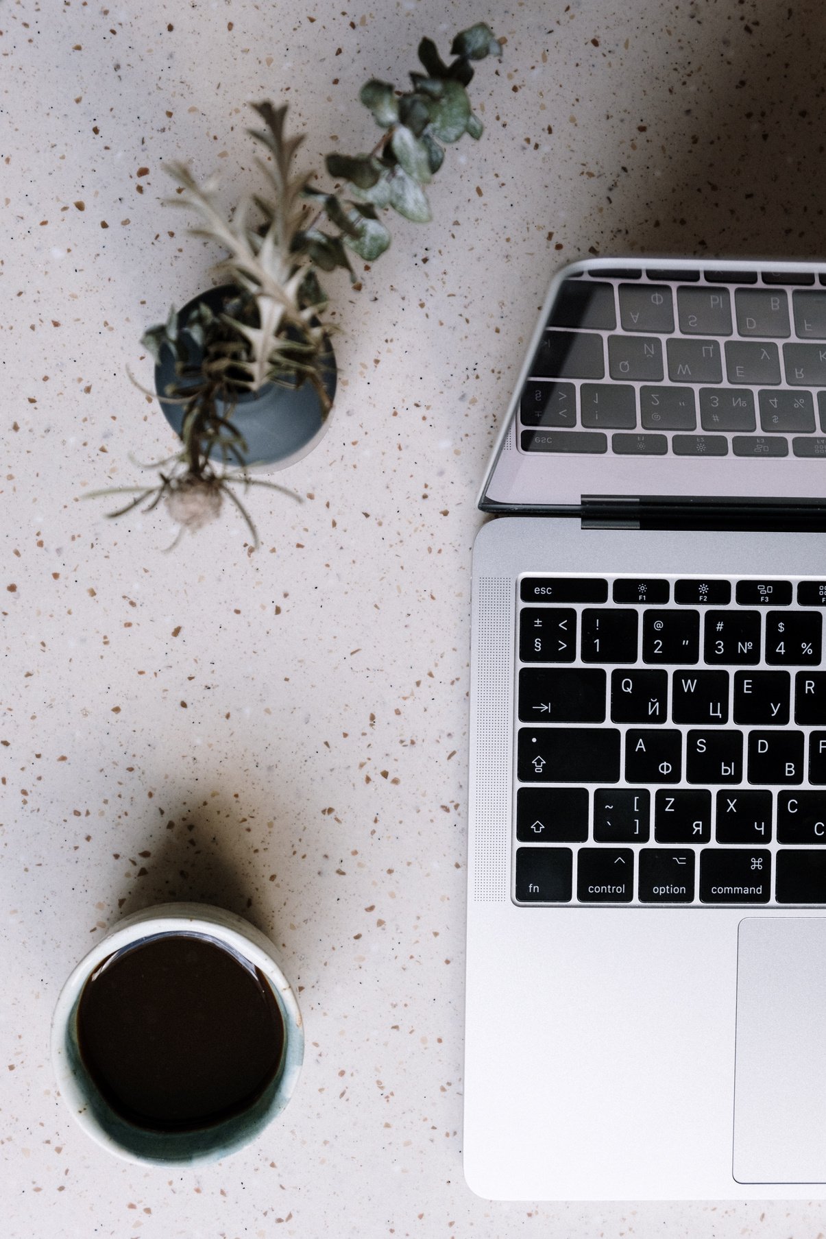 Macbook Pro Beside Silver and Black Cup